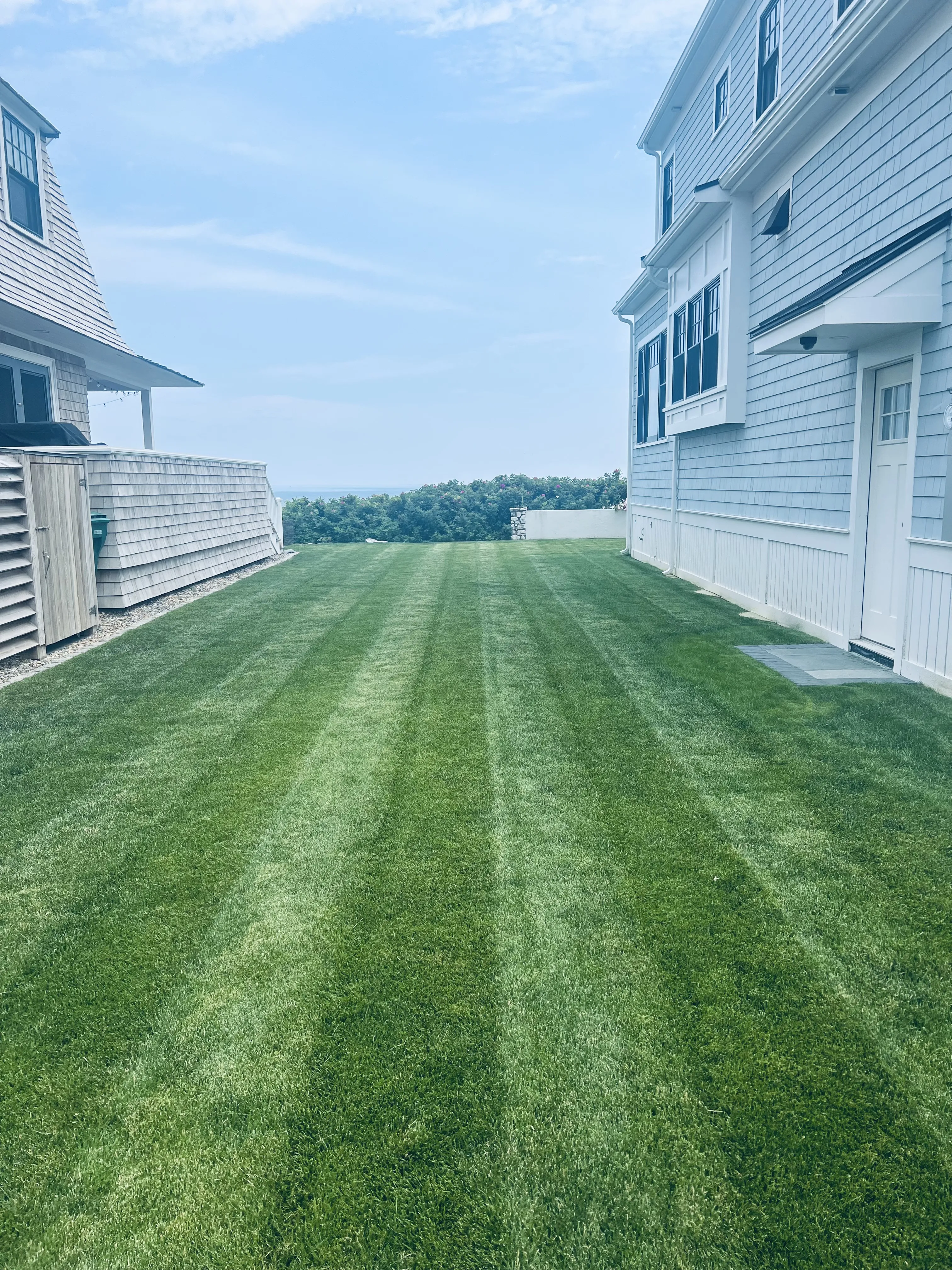 Completed front yard makeover with trimmed shrubs and clean hardscape edge