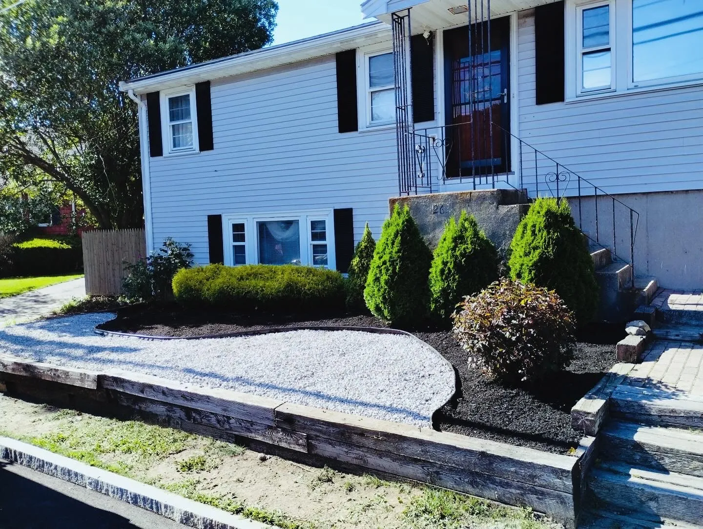 Stone bordered garden area after maintenance with defined lawn edge